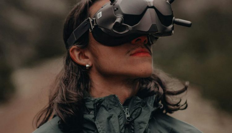 A person wearing FPV goggles enjoys the forest outdoors, showcasing adventure and technology.