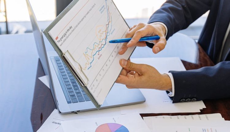 Business professionals discussing financial graphs and charts in an office setting.