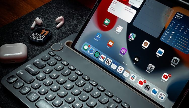 A cozy workspace featuring an iPad with a keyboard, AirPods, and elegant lighting.